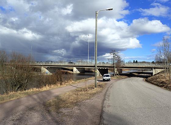 Valokuva, jossa taustalla silta, jonka alittaa maantie ja kevyen liikenteen väylä.